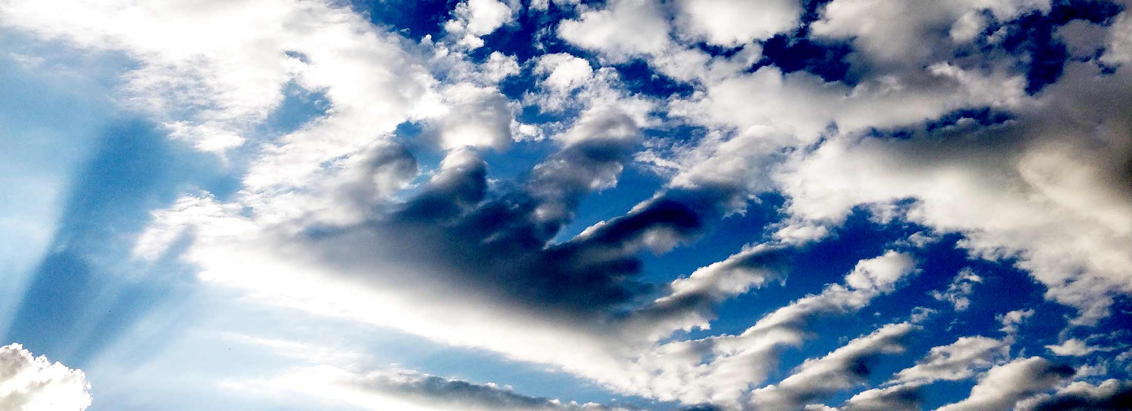 The sky full of clouds that look like fingers reaching. Sun rays in the corner.